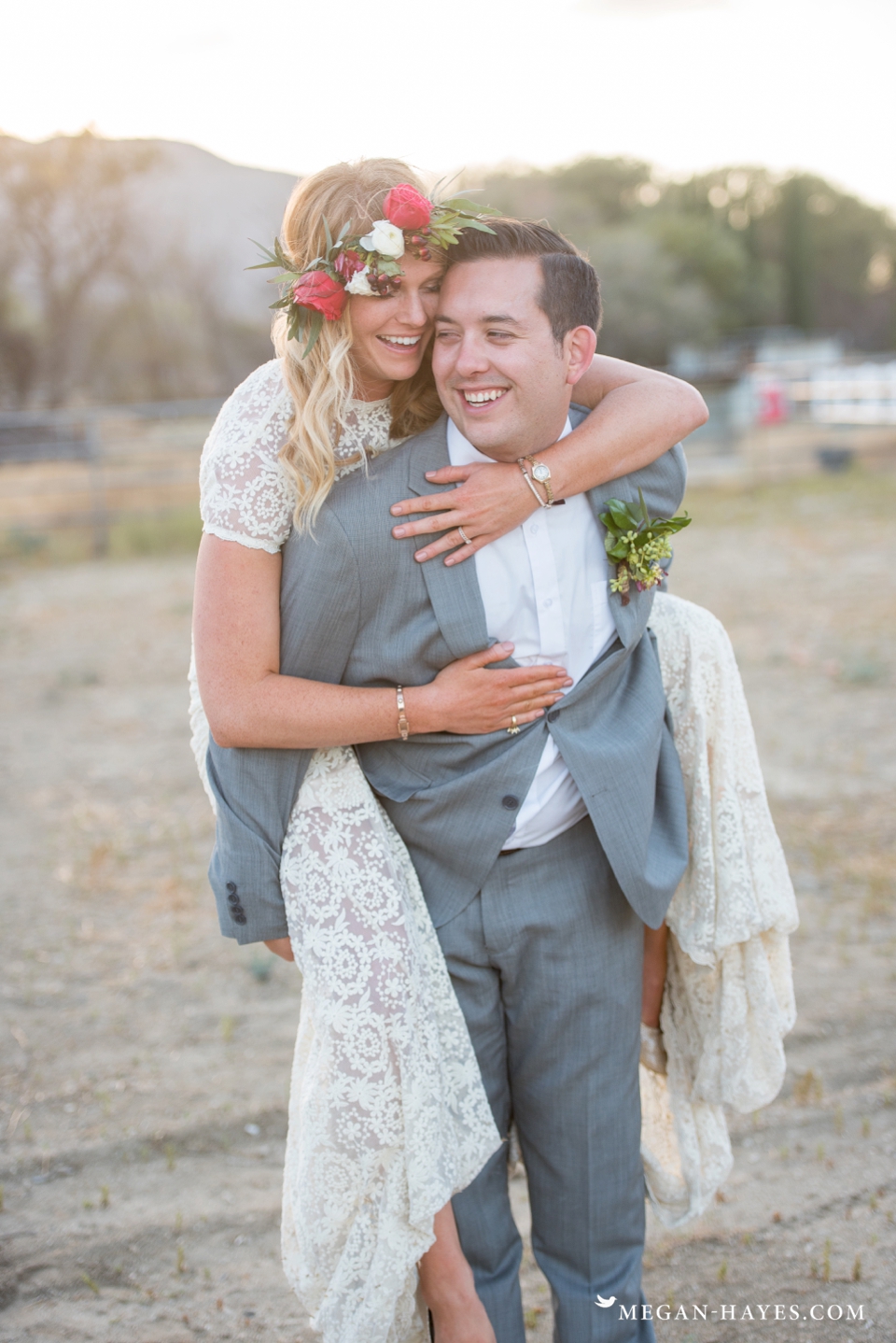 a-bride-piggyback-rides-her-husband-while-wearing-her-backless-lace-bohemian-wedding-dress-a-testament-to-its-comfort