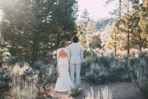 bohemian-bride-out-in-the-woods-wearing-backless-lace-wedding-dress-with-her-groom