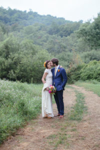 boho-bride-Adrianna-with-groom-in-fields-her-wearing-lace-backless-dress-with-keyhole-back