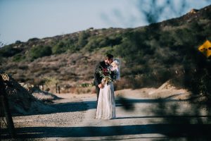 a-california-wedding-featuring-bride-and-groom-in-open-field-her-with-an-oversized-bouquet