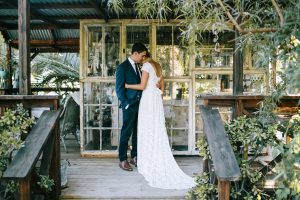 bride-and-groom-in-a-greenery-filled-backdrop-on-their-wedding-day