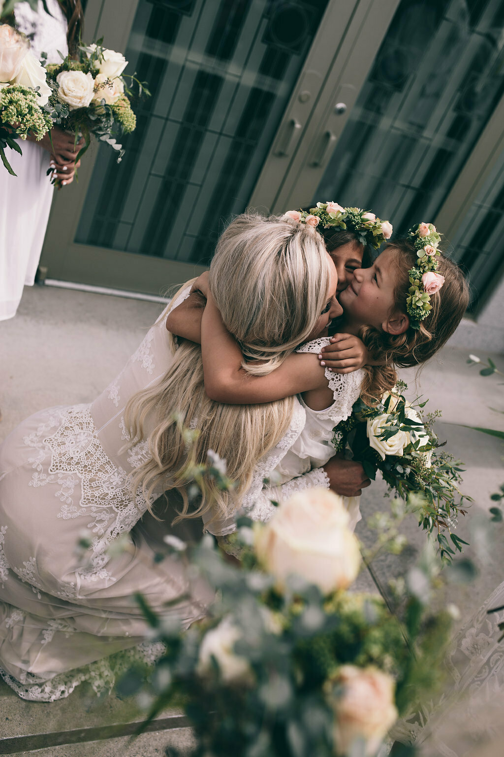 bride-lizzy-sharing-a-hug-with-her-bohemian-flower-girls-wearing-boho-white-and-green-simple-flower-crowns