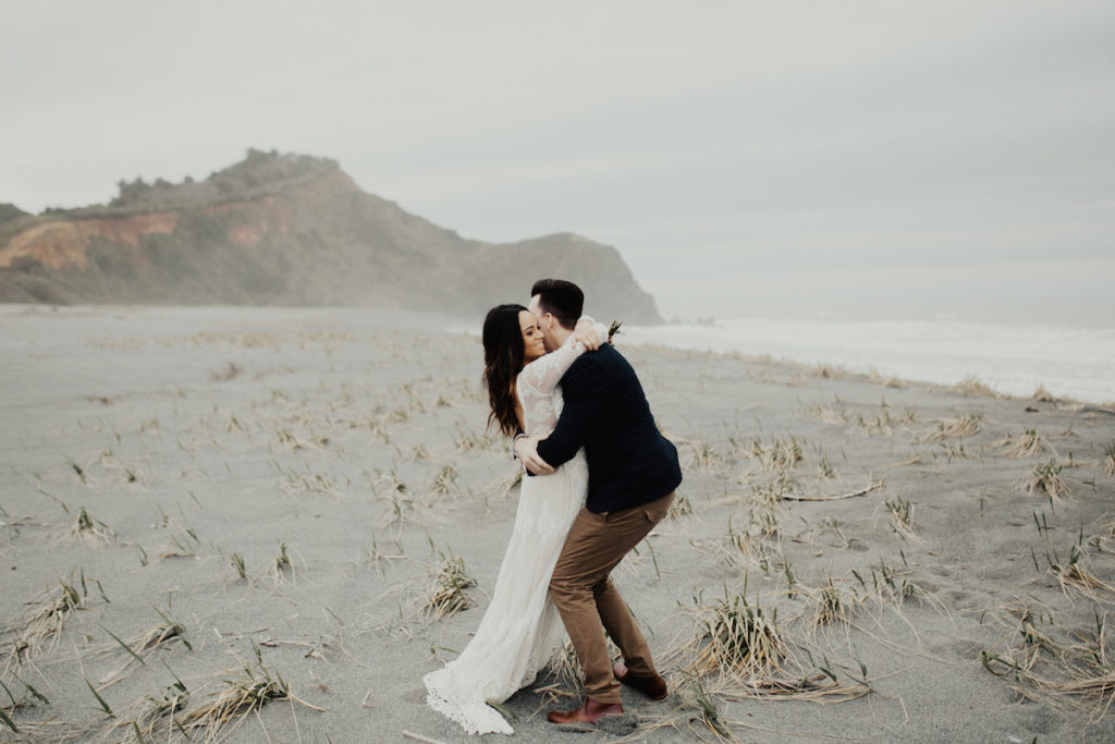 natural-bride-wearing-an-ethereal-lace-gown-on-a-deserted-beach-boho-brides-inspiration