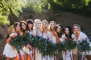bridesmaids-with-greenery-bouquet-and-mismatched-white-dresses-boho-wedding-inspiration
