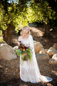 bride-medan-holding-an-oversized-bouquet-dressed-in-a-long-sleeved-lace-vintage-style-wedding-dress