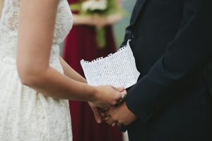 closeup-view-of-the-bride-holding-her-handwritten-vows-during-their-intimate-boho-hilltop-wedding