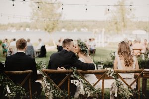 bride-sitting-at-lakefront-michigan-bohemian-wedding-filled-with-greenery