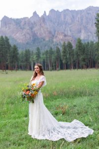 Bride wearing off shoulder lace wedding dress pin Colorado
