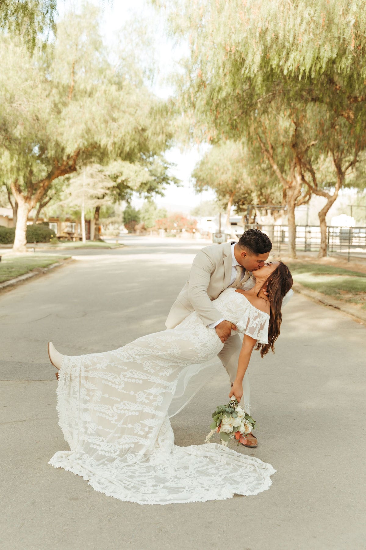 Emily-and-Chris-kissing-at-their-ranch-boho-wedding