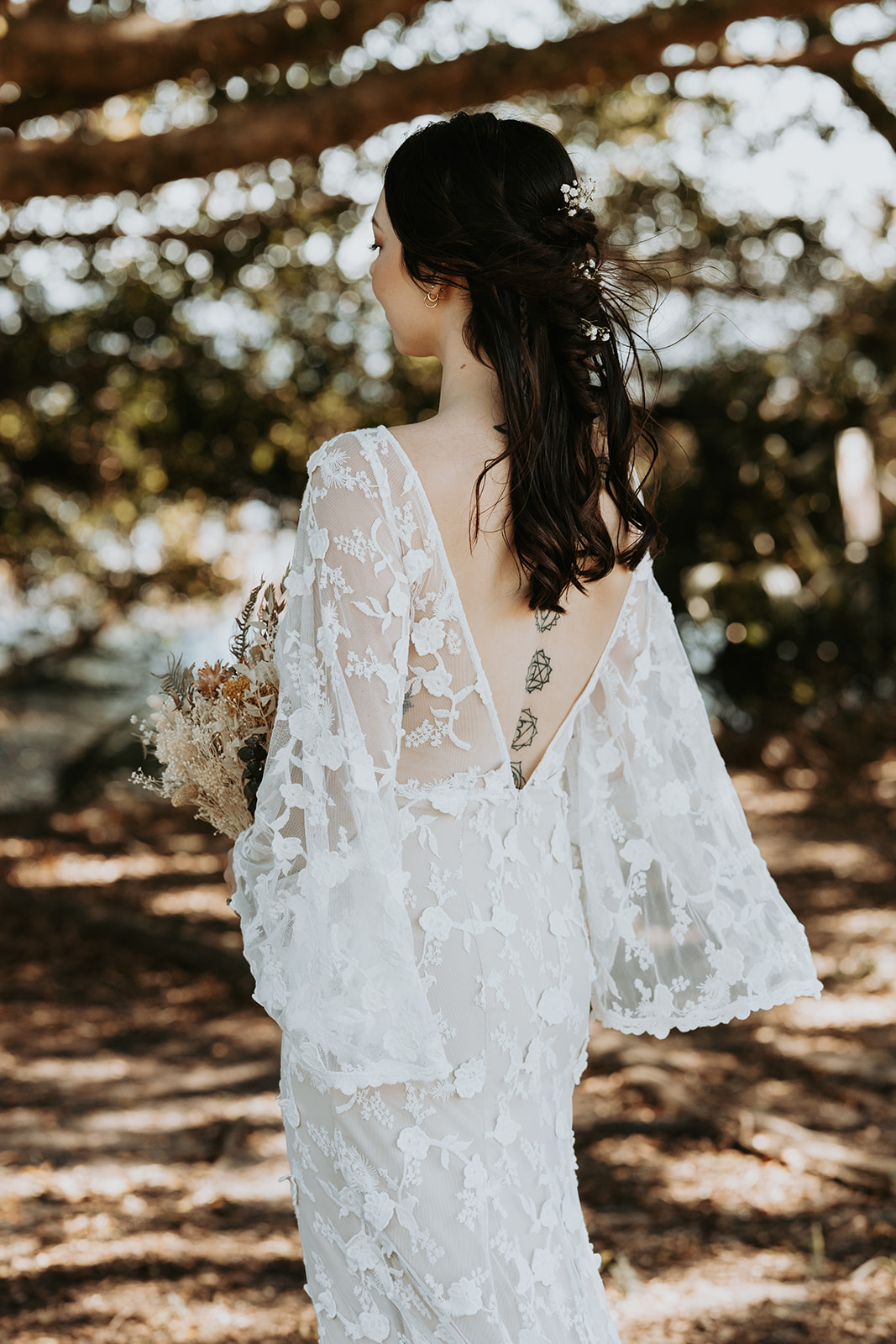bride-in-the-ooutdoors-wearing-a-lace-backless-wedding-dress