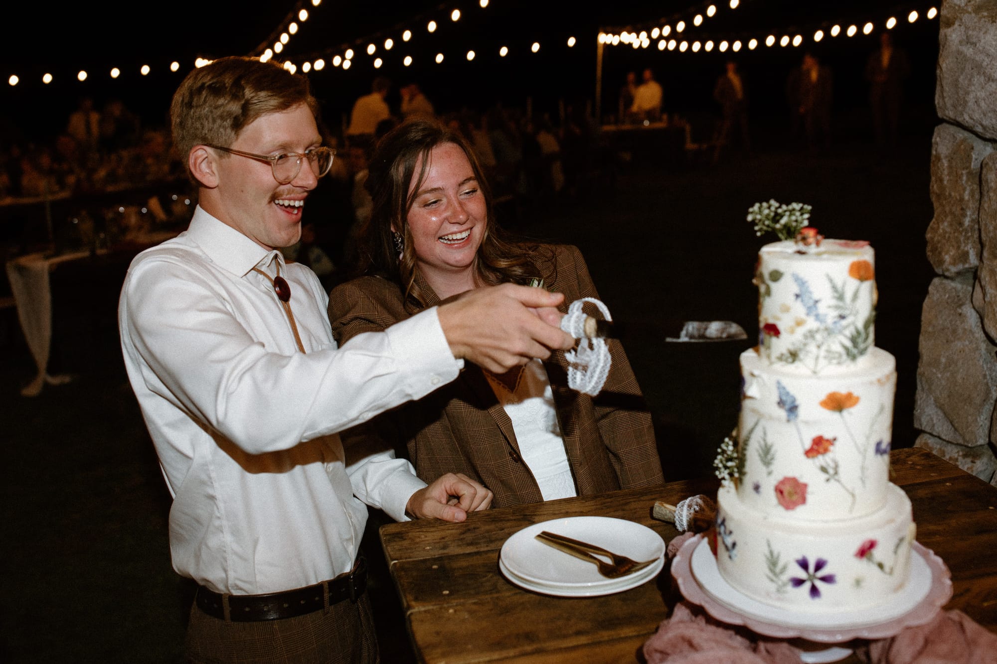 the-cuttong-of-the-flower-pressed-tiered-cake-boho-wedding-inspo