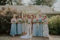 Bride Sophia wearing Penelope Dress Califonia-bride-with-her-bridesmaids-they-wear-blue-while-she-wears-the-Dreamers-and-Lovers-Penelope-Lace-Dress-with-Open-Back-and-Front-Slit