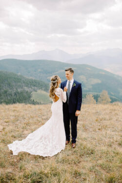 Bride Christian in Violetta | @Carlyandoltphoto bride-wearing-violetta-long-sleeves-lace-gown-against-the-mountain-backdrop