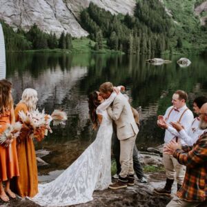 Real Bride in Alaska on the lake wearing the Violetta lace wedding dress with long sleeves and a dreamy open back