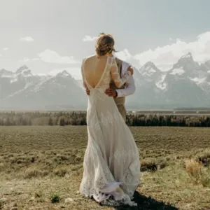 Real bride in the mountains on her wedding day wearing a backless lace boho wedding dress | Book your LA bridal appointment