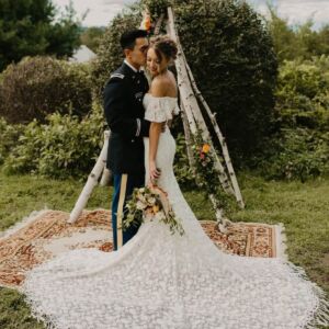 Bride Zoe wearing Callista off‑shoulder lace wedding dress among redwoods